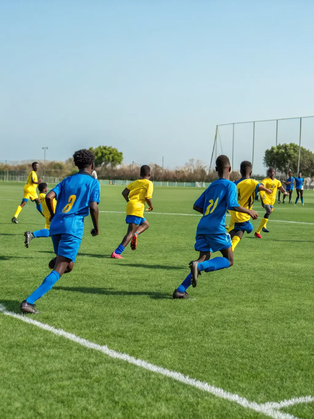 Students engaged in a soccer match on the school's soccer field, highlighting teamwork and strategic play.